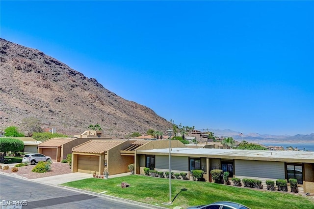 532 Greenbriar Pl, Boulder City, NV 89005 - view of front of property with a mountain view, a front lawn, stucco siding, and driveway