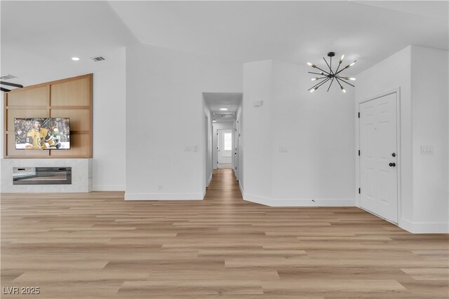 3109 Siena Cir, Las Vegas, NV 89128 - unfurnished living room with a chandelier, light wood-style floors, baseboards, recessed lighting, and a large fireplace