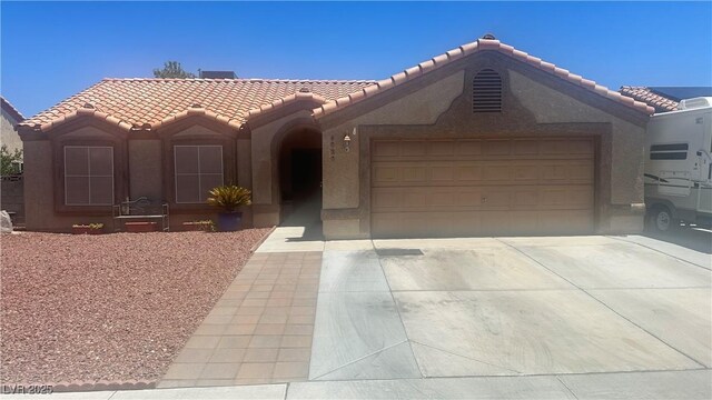 5020 Wildroot Rd, Las Vegas, NV 89130 - view of front of property with a tiled roof, stucco siding, concrete driveway, and an attached garage