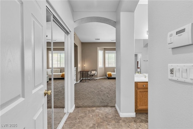 9362 Wilderness Glen Ave, Las Vegas, NV 89178 - hall with arched walkways, light carpet, healthy amount of natural light, and baseboards