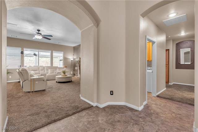 9362 Wilderness Glen Ave, Las Vegas, NV 89178 - carpeted living room featuring arched walkways, ceiling fan, baseboards, and tile patterned flooring