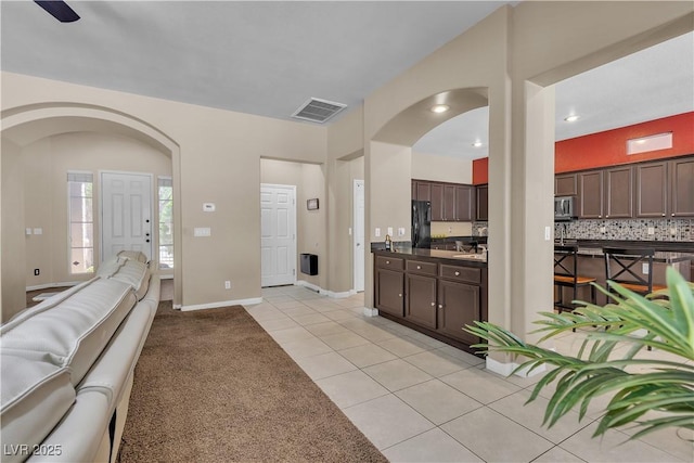 9362 Wilderness Glen Ave, Las Vegas, NV 89178 - living area featuring light tile patterned floors, arched walkways, and baseboards