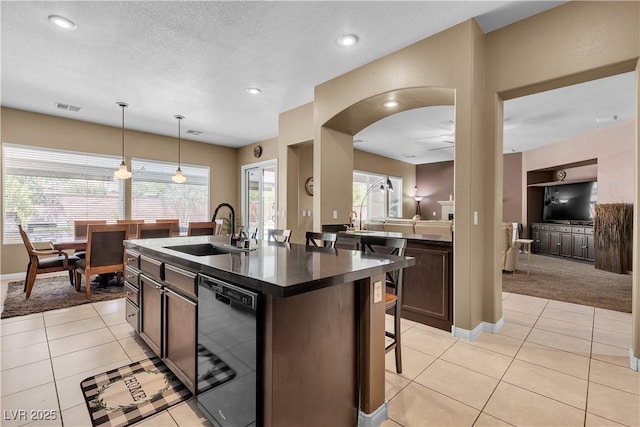9362 Wilderness Glen Ave, Las Vegas, NV 89178 - kitchen with dishwasher, a sink, dark countertops, dark brown cabinets, and an island with sink