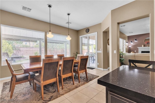 9362 Wilderness Glen Ave, Las Vegas, NV 89178 - dining area with light tile patterned flooring, a fireplace, and baseboards