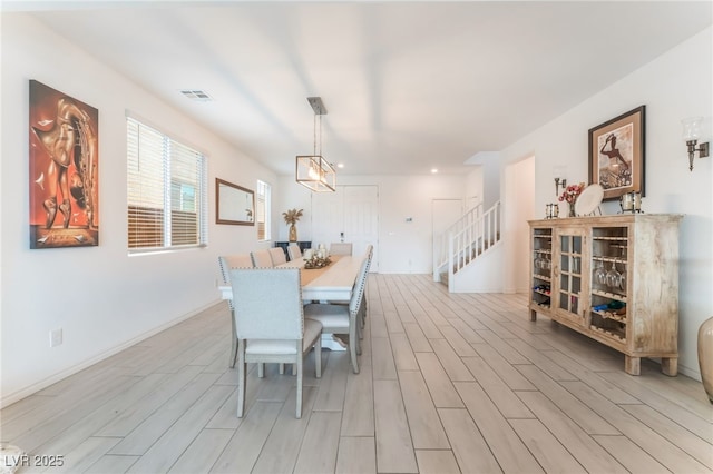7107 Calvert Cliffs St, North Las Vegas, NV 89084 - dining room featuring light wood-type flooring, stairs, baseboards, and a chandelier