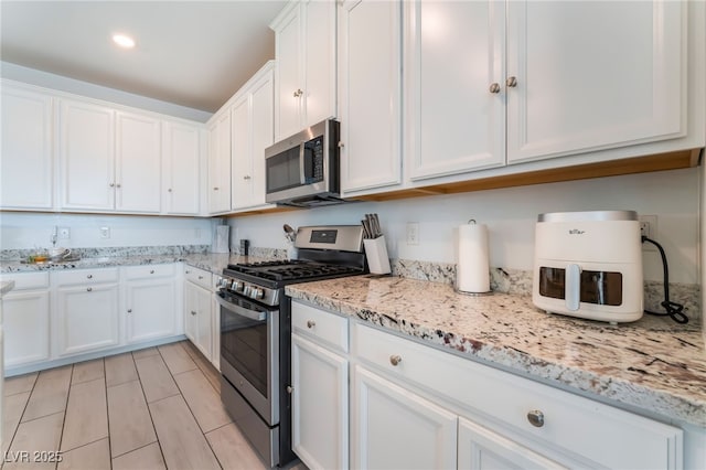 7107 Calvert Cliffs St, North Las Vegas, NV 89084 - kitchen featuring appliances with stainless steel finishes, white cabinetry, light stone countertops, and recessed lighting