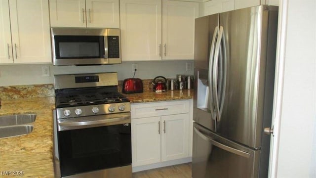 4821 Black Bear Rd Unit 104, Las Vegas, NV 89149 - kitchen with appliances with stainless steel finishes, white cabinets, and a sink