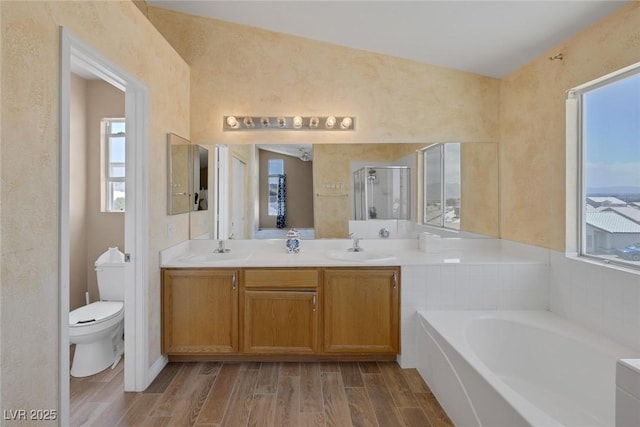 2147 Bridle Wreath Ln, Las Vegas, NV 89156 - bathroom featuring toilet, wood finished floors, a bath, and double vanity