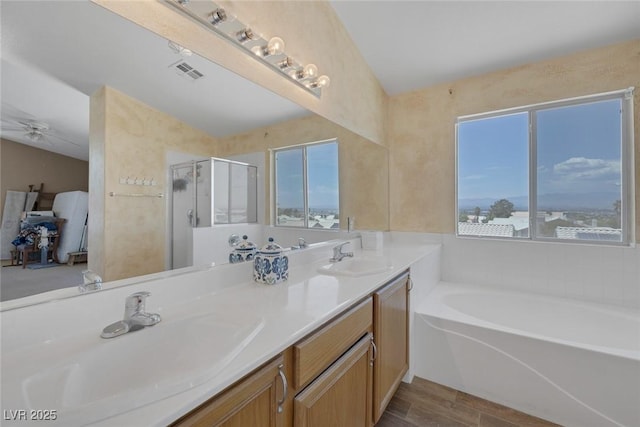 2147 Bridle Wreath Ln, Las Vegas, NV 89156 - bathroom featuring a garden tub, a stall shower, double vanity, wood finished floors, and ceiling fan