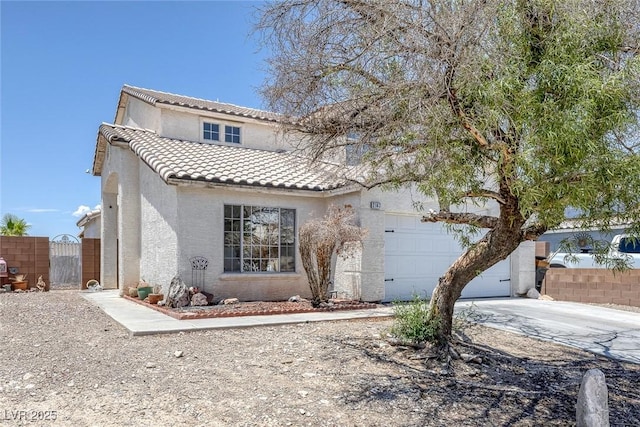 2147 Bridle Wreath Ln, Las Vegas, NV 89156 - mediterranean / spanish home with a tiled roof, stucco siding, an attached garage, a gate, and concrete driveway