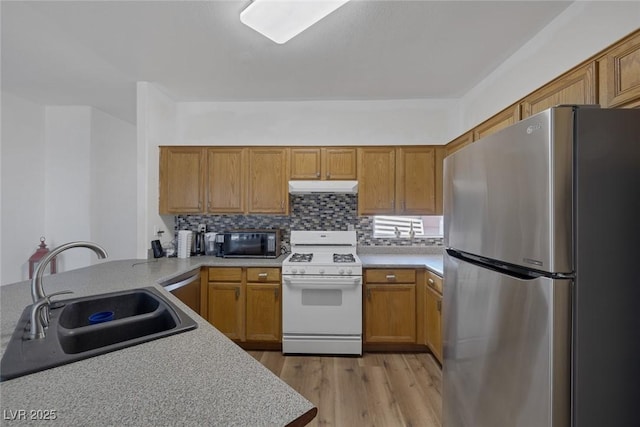 2147 Bridle Wreath Ln, Las Vegas, NV 89156 - kitchen featuring freestanding refrigerator, white gas range, under cabinet range hood, black microwave, and a sink