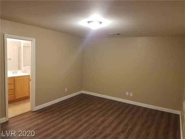 8982 Leaping Pad Ct, Las Vegas, NV 89148 - unfurnished room featuring dark wood-type flooring, baseboards, and a sink