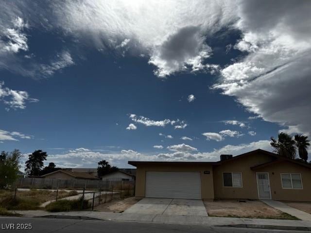 4189 Studio St, Las Vegas, NV 89115 - ranch-style house with stucco siding, an attached garage, fence, and concrete driveway