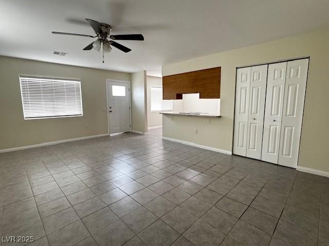 4189 Studio St, Las Vegas, NV 89115 - unfurnished living room with ceiling fan, dark tile patterned floors, and baseboards