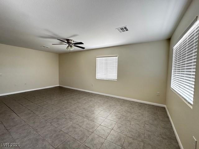 4189 Studio St, Las Vegas, NV 89115 - empty room with plenty of natural light, a ceiling fan, and baseboards