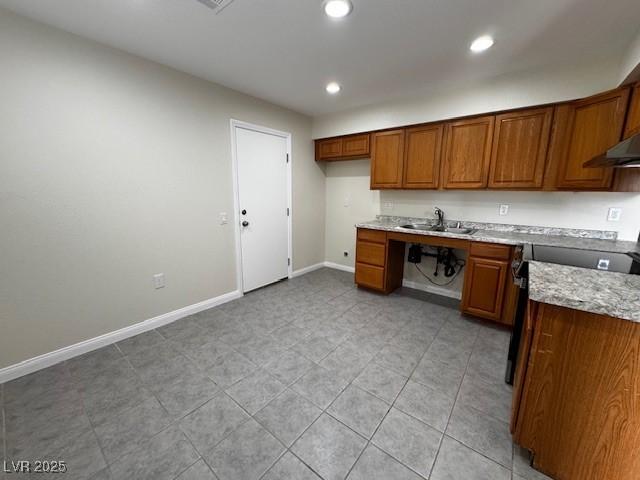 4189 Studio St, Las Vegas, NV 89115 - kitchen featuring brown cabinetry, baseboards, range, a sink, and recessed lighting