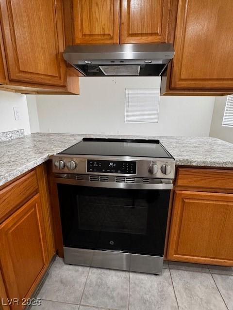 4189 Studio St, Las Vegas, NV 89115 - kitchen featuring stainless steel range with electric cooktop, extractor fan, and brown cabinetry