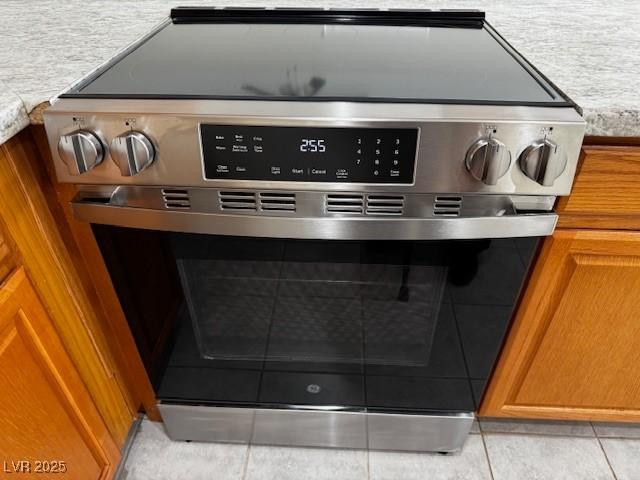 4189 Studio St, Las Vegas, NV 89115 - detailed view of stainless steel electric range oven, brown cabinets, and light countertops