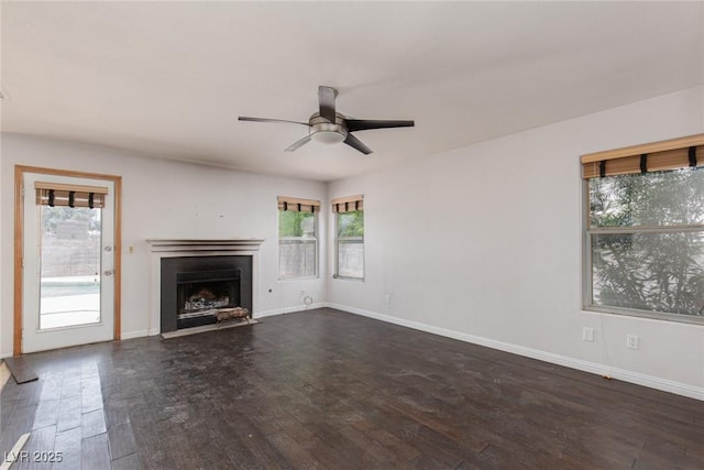 1924 Coralino Dr, Henderson, NV 89074 - unfurnished living room featuring a ceiling fan, dark wood finished floors, a fireplace with flush hearth, and baseboards