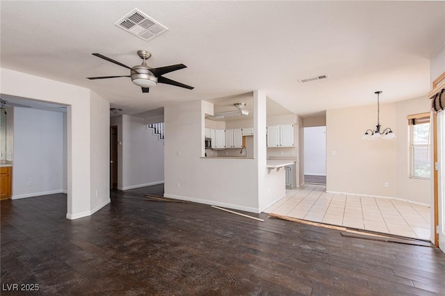 1924 Coralino Dr, Henderson, NV 89074 - unfurnished living room with a ceiling fan, wood finished floors, a chandelier, and baseboards