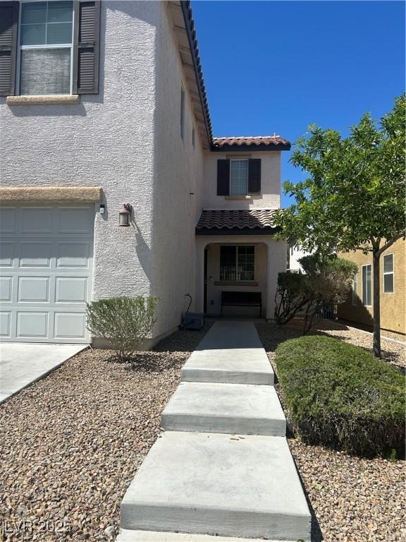9082 Amanda Creek Ct, Las Vegas, NV 89149 - view of front facade featuring stucco siding, a tiled roof, and a garage