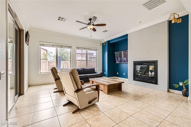 7404 Eggshell Dr, North Las Vegas, NV 89084 - living room with light tile patterned floors, crown molding, a ceiling fan, a glass covered fireplace, and baseboards