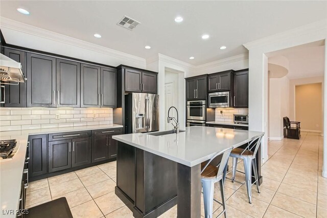 7404 Eggshell Dr, North Las Vegas, NV 89084 - kitchen featuring a sink, stainless steel appliances, light tile patterned floors, backsplash, and ornamental molding