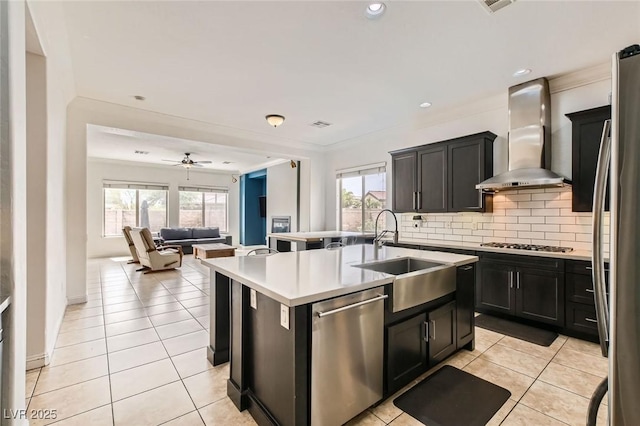 7404 Eggshell Dr, North Las Vegas, NV 89084 - kitchen with stainless steel appliances, wall chimney exhaust hood, a sink, open floor plan, and an island with sink