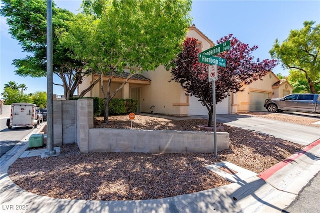 7912 Horn Beam Ct, Las Vegas, NV 89131 - obstructed view of property featuring stucco siding, driveway, and an attached garage