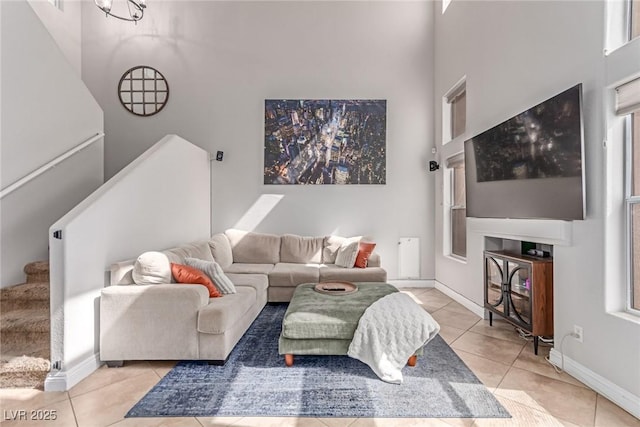 7912 Horn Beam Ct, Las Vegas, NV 89131 - living area featuring light tile patterned floors, stairs, a towering ceiling, and baseboards