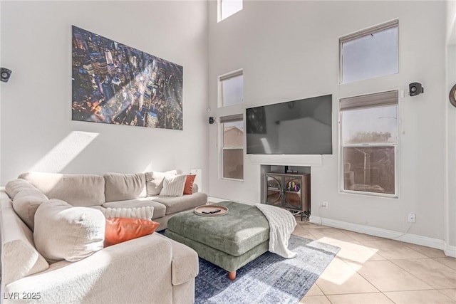 7912 Horn Beam Ct, Las Vegas, NV 89131 - tiled living room with a towering ceiling, a glass covered fireplace, and baseboards