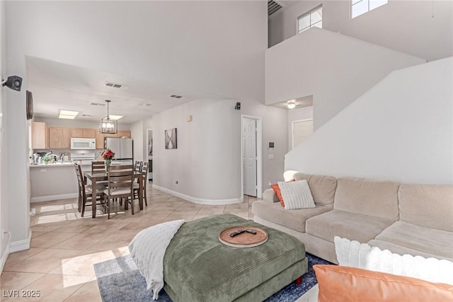 7912 Horn Beam Ct, Las Vegas, NV 89131 - living room with light tile patterned floors, a high ceiling, and baseboards