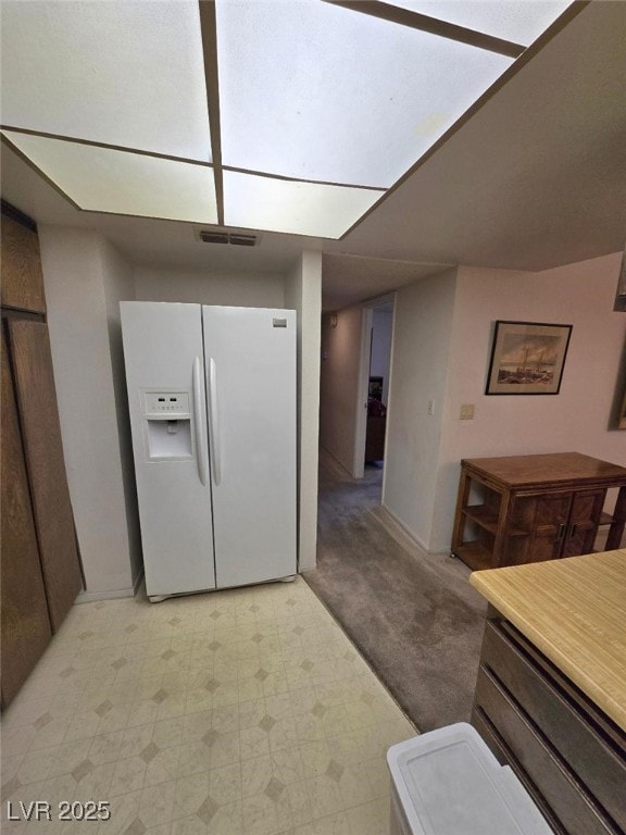 3660 Haverhill St, Las Vegas, NV 89121 - kitchen with white fridge with ice dispenser, light flooring, and baseboards