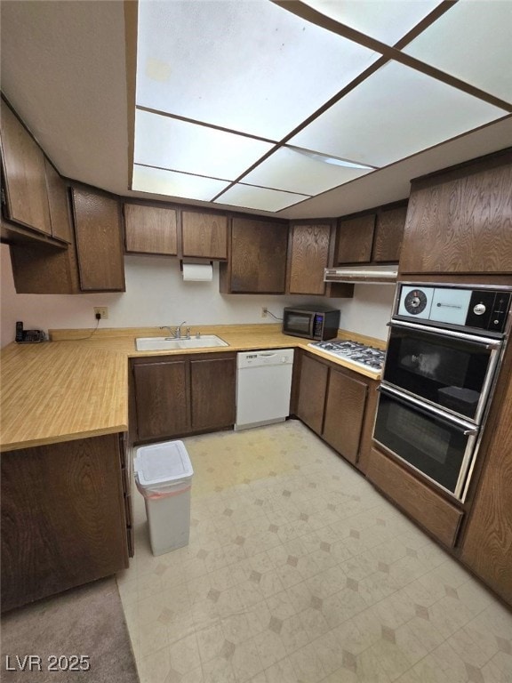 3660 Haverhill St, Las Vegas, NV 89121 - kitchen with black appliances, a sink, dark brown cabinetry, light countertops, and light flooring