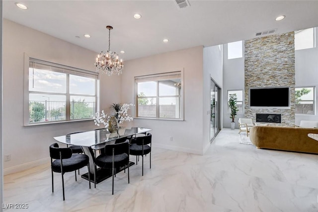 350 Gandara St, Las Vegas, NV 89138 - dining room with a stone fireplace, a chandelier, recessed lighting, baseboards, and light marble finish flooring
