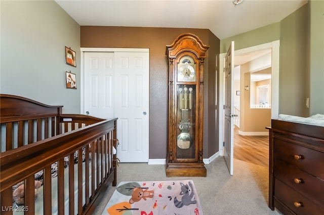 carpeted bedroom with a closet and baseboards