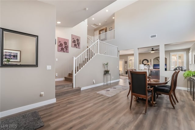 dining space with baseboards, wood finished floors, stairway, recessed lighting, and ceiling fan
