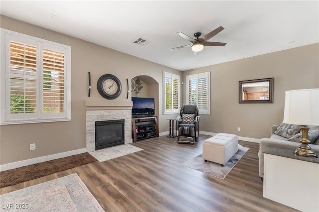 living room featuring a ceiling fan, plenty of natural light, baseboards, and wood finished floors