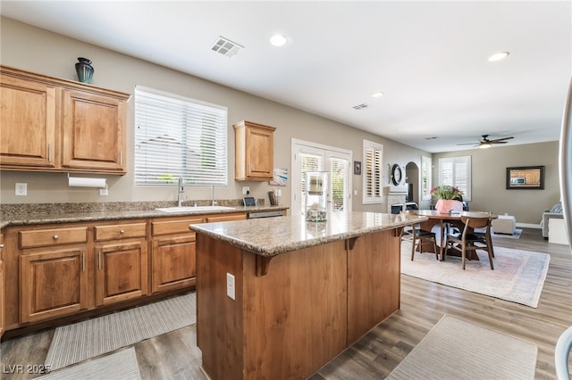 kitchen featuring a sink, a center island, recessed lighting, ceiling fan, and dark wood-style floors