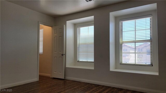 386 Botanic Gardens Dr, Las Vegas, NV 89148 - unfurnished room with baseboards and dark wood-style flooring