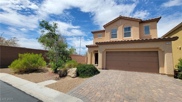 386 Botanic Gardens Dr, Las Vegas, NV 89148 - mediterranean / spanish-style home featuring stucco siding, fence, an attached garage, and driveway