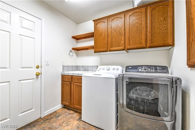 laundry room with cabinet space, washer and dryer, and baseboards