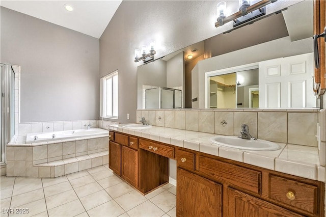 full bath with tile patterned flooring, a bath, double vanity, a shower stall, and high vaulted ceiling