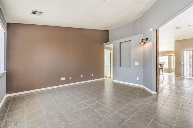 tiled spare room featuring baseboards