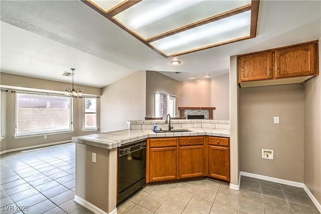 kitchen featuring black dishwasher, a sink, brown cabinetry, a chandelier, and light tile patterned floors
