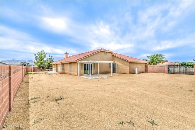 back of house with stucco siding, a patio area, a fenced backyard, a chimney, and a pergola