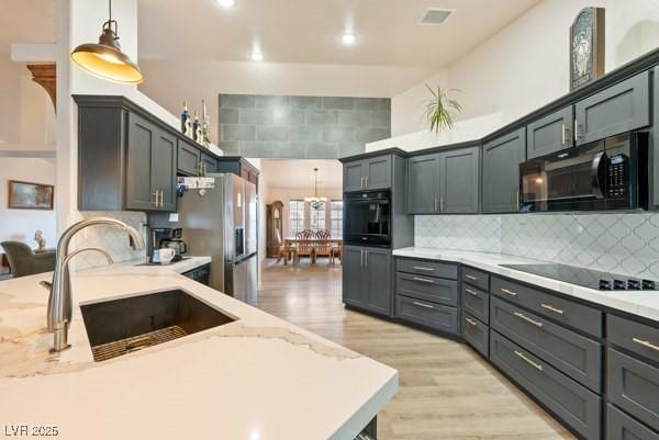 1251 Cavalry St, Pahrump, NV 89048 - kitchen with black appliances, a sink, light wood-style flooring, decorative light fixtures, and recessed lighting