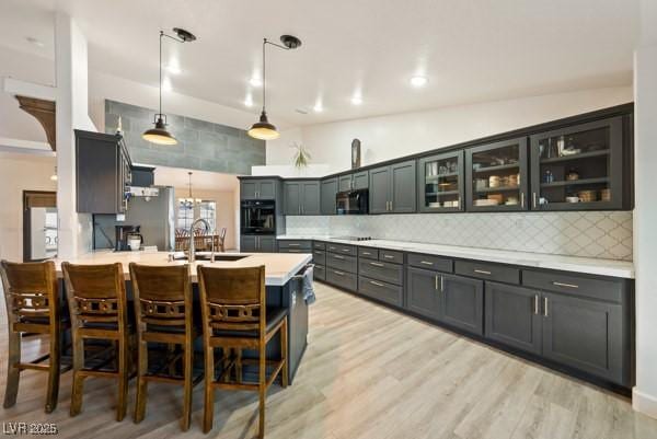 1251 Cavalry St, Pahrump, NV 89048 - kitchen with black appliances, a kitchen breakfast bar, a peninsula, light countertops, and backsplash