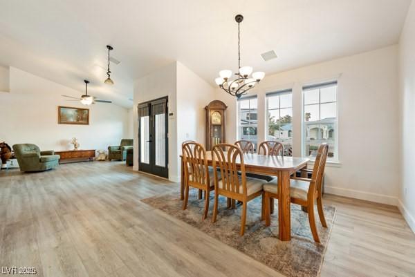 1251 Cavalry St, Pahrump, NV 89048 - dining room with a chandelier, light wood-style flooring, baseboards, ceiling fan, and vaulted ceiling
