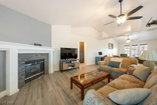 1251 Cavalry St, Pahrump, NV 89048 - living room featuring ceiling fan, vaulted ceiling, a fireplace, and light wood-type flooring